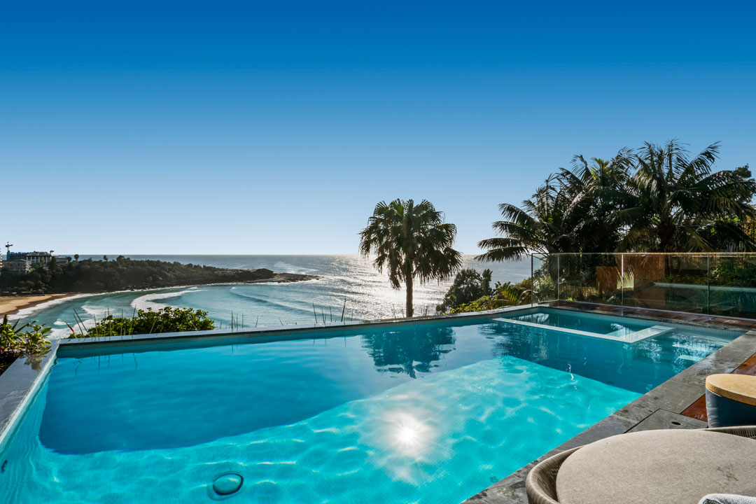 TradeMark Pools pool with glass fence and deck 